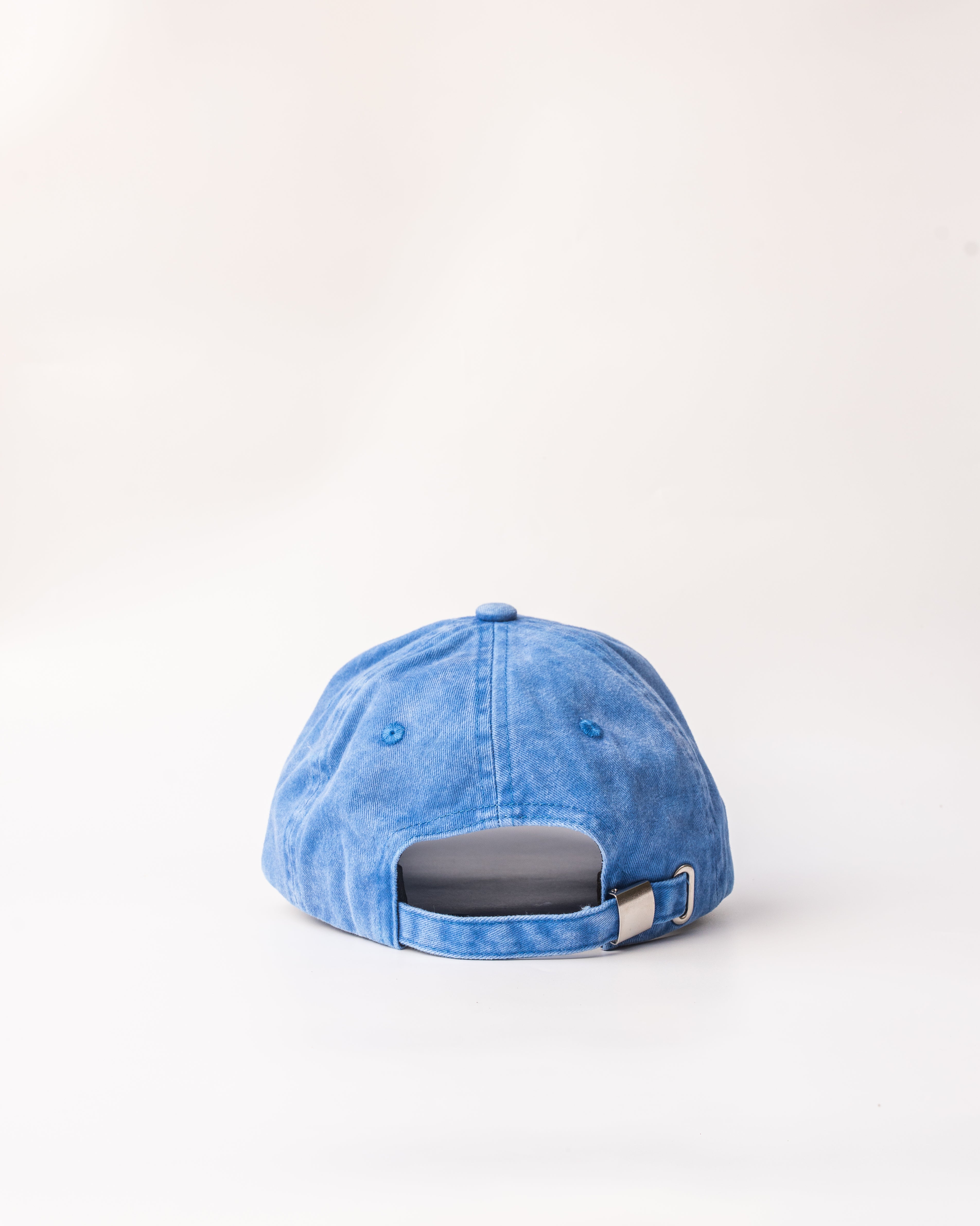Casquette bleue délavée – vue de dos Vue arrière de la casquette avec fermeture réglable en métal doré, style décontracté et estival.