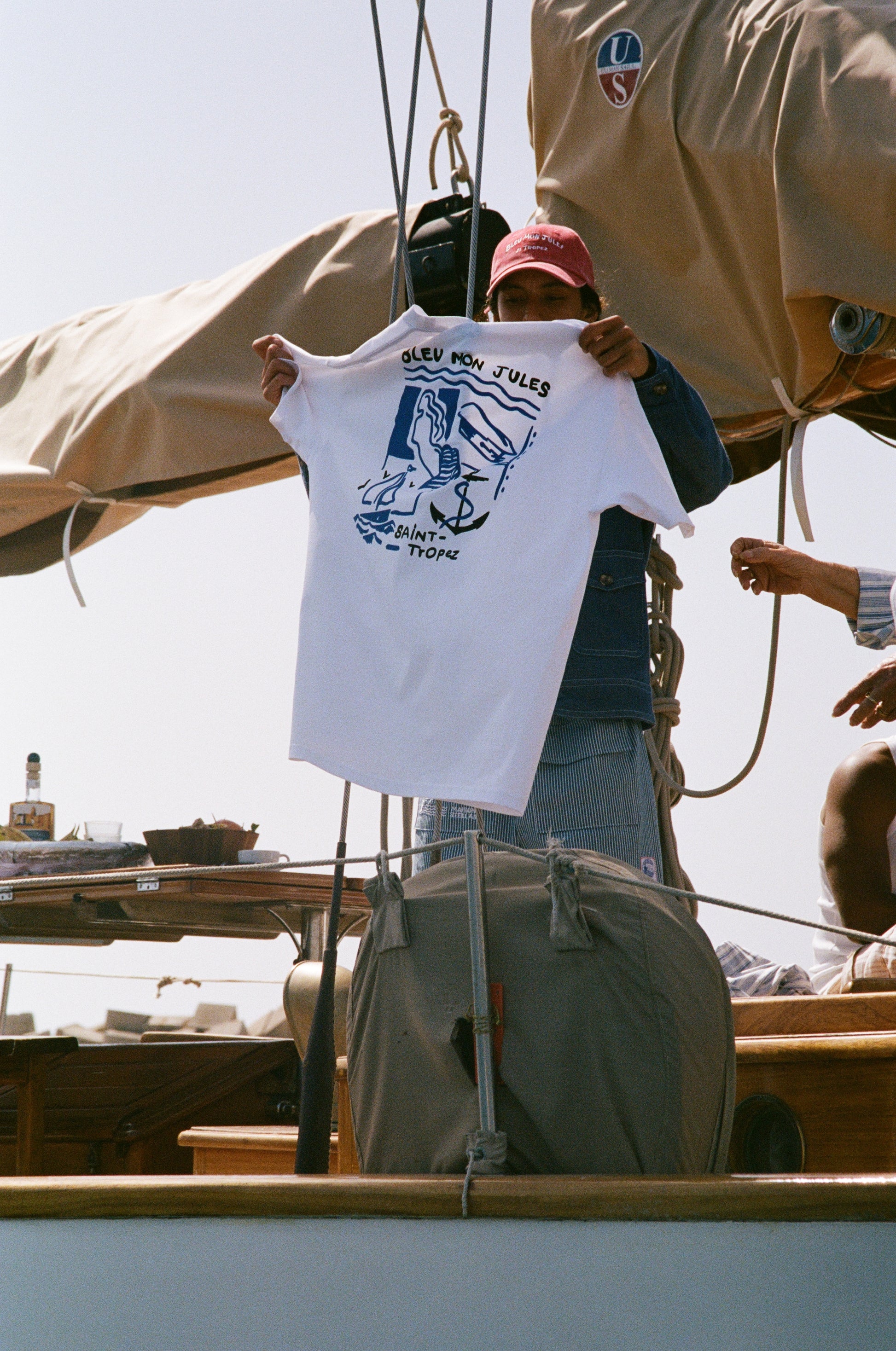 T-shirt blanc Carré Bleu à bord de voilier, motif Saint-Tropez dessiné à main levée avec silhouette, ancre et palmier