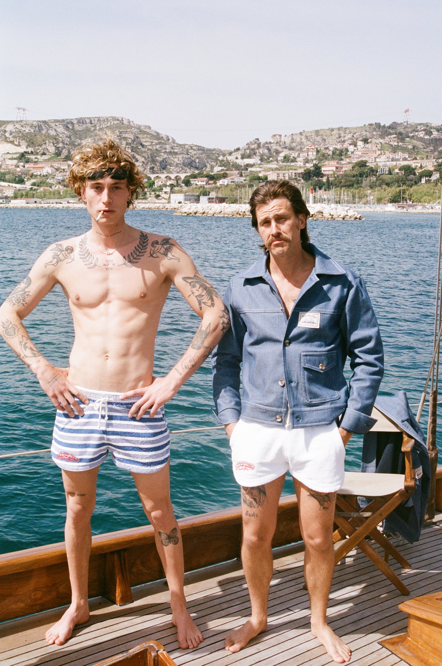 Homme portant short rayé bleu blanc Éponge, tissu méditerranéen absorbant avec broderie Saint-Tropez sur pontons