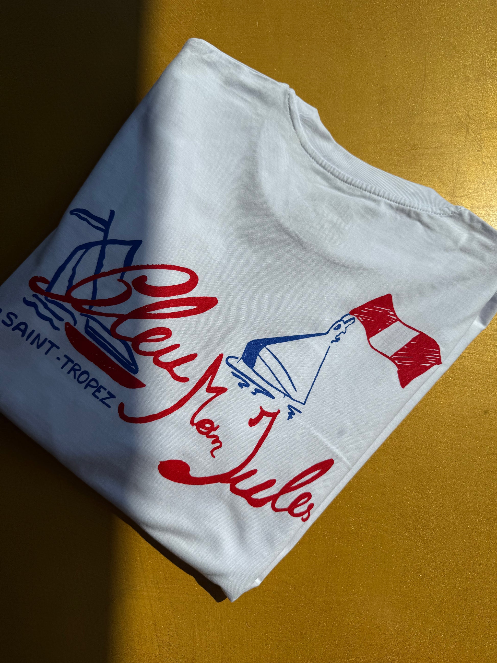 Détail du motif Bouée sur tissu blanc – Gros plan sur l’inscription “Bouée Saint-Tropez” imprimée sur le coton, accent nautique et graphique.