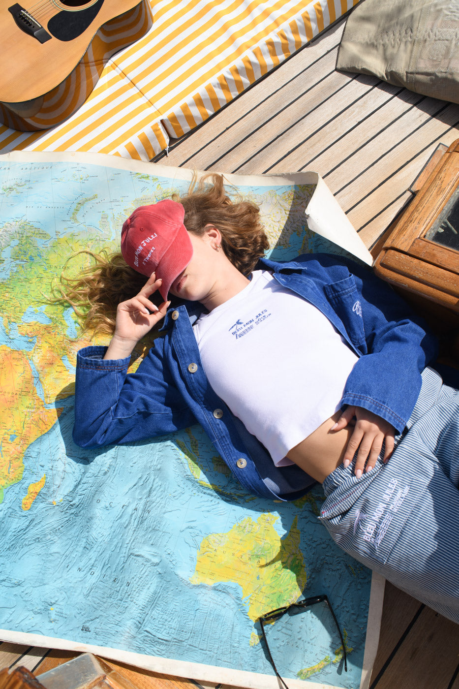 Femme allongée sur une mappemonde portant débardeur coton côtelé blanc brodé Bleu mon Jules Côte d'Azur