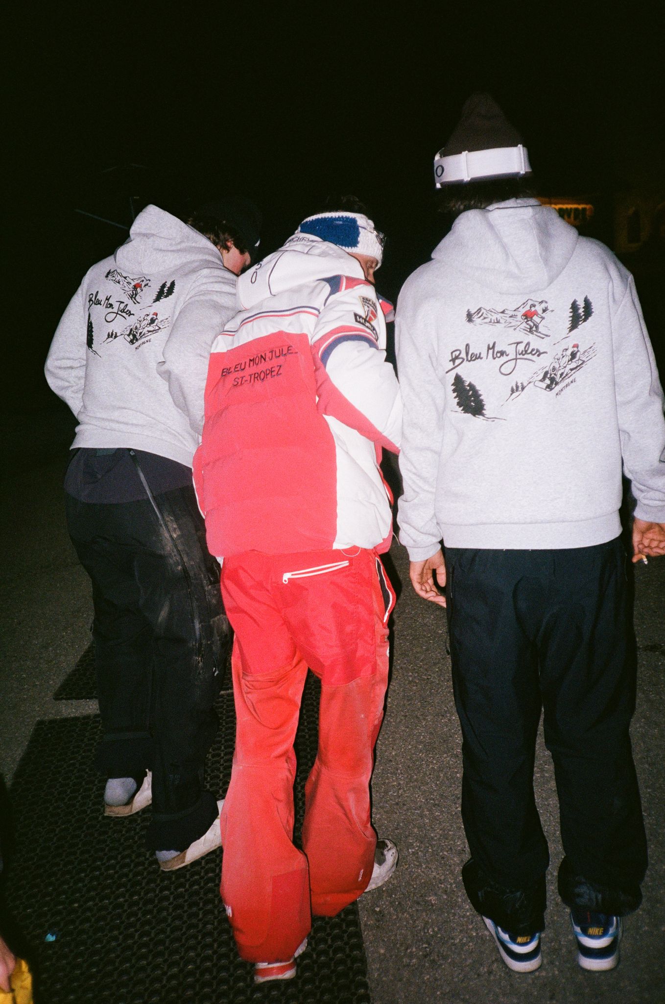 Groupe portant le sweat gris Too Schuss collection hiver 2025, inspiré des paysages enneigés alpins avec design rétro vintage