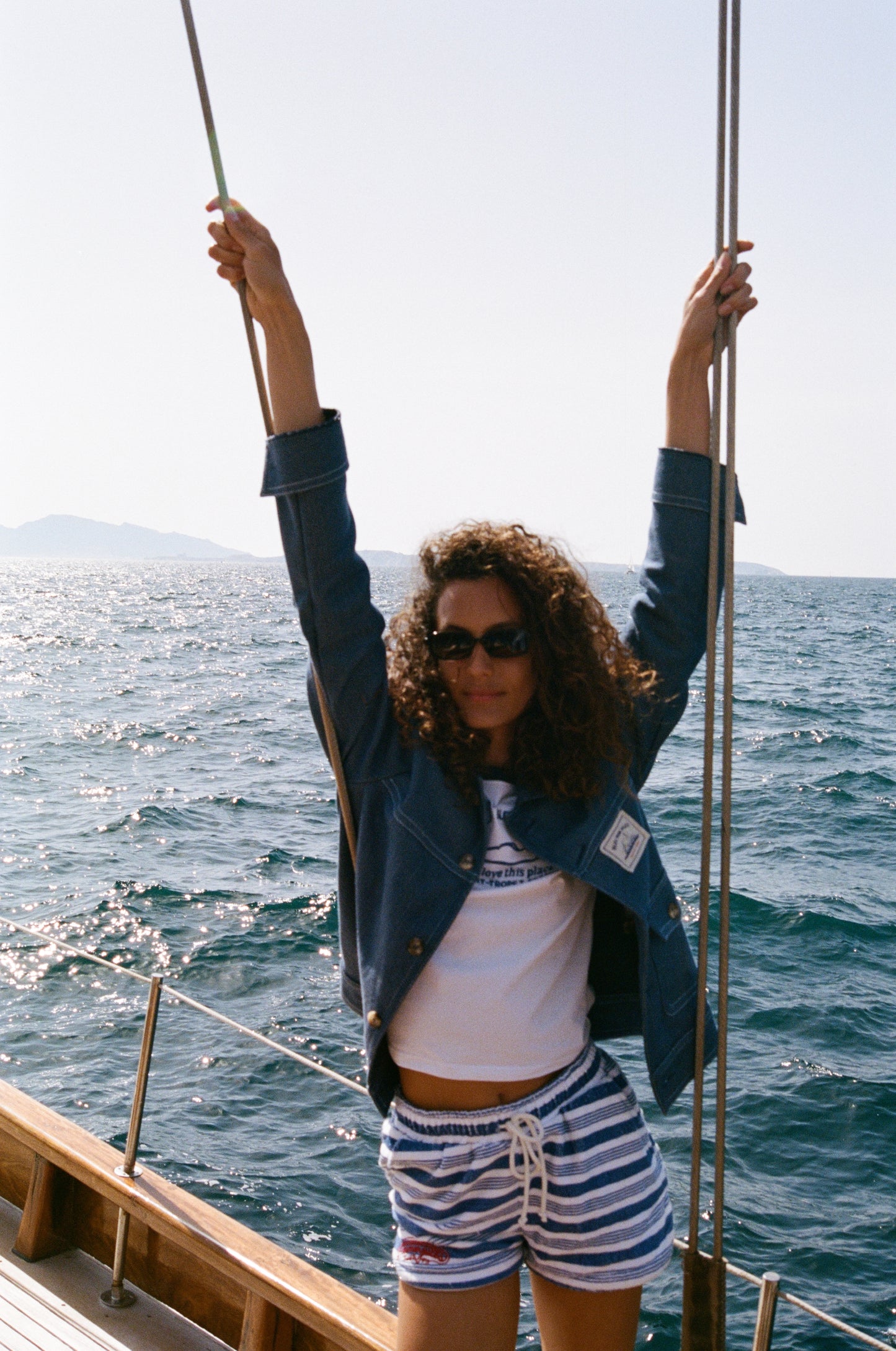 Veste jean Bleu mon Jules portée ouverte sur t-shirt, bord de mer, voilier