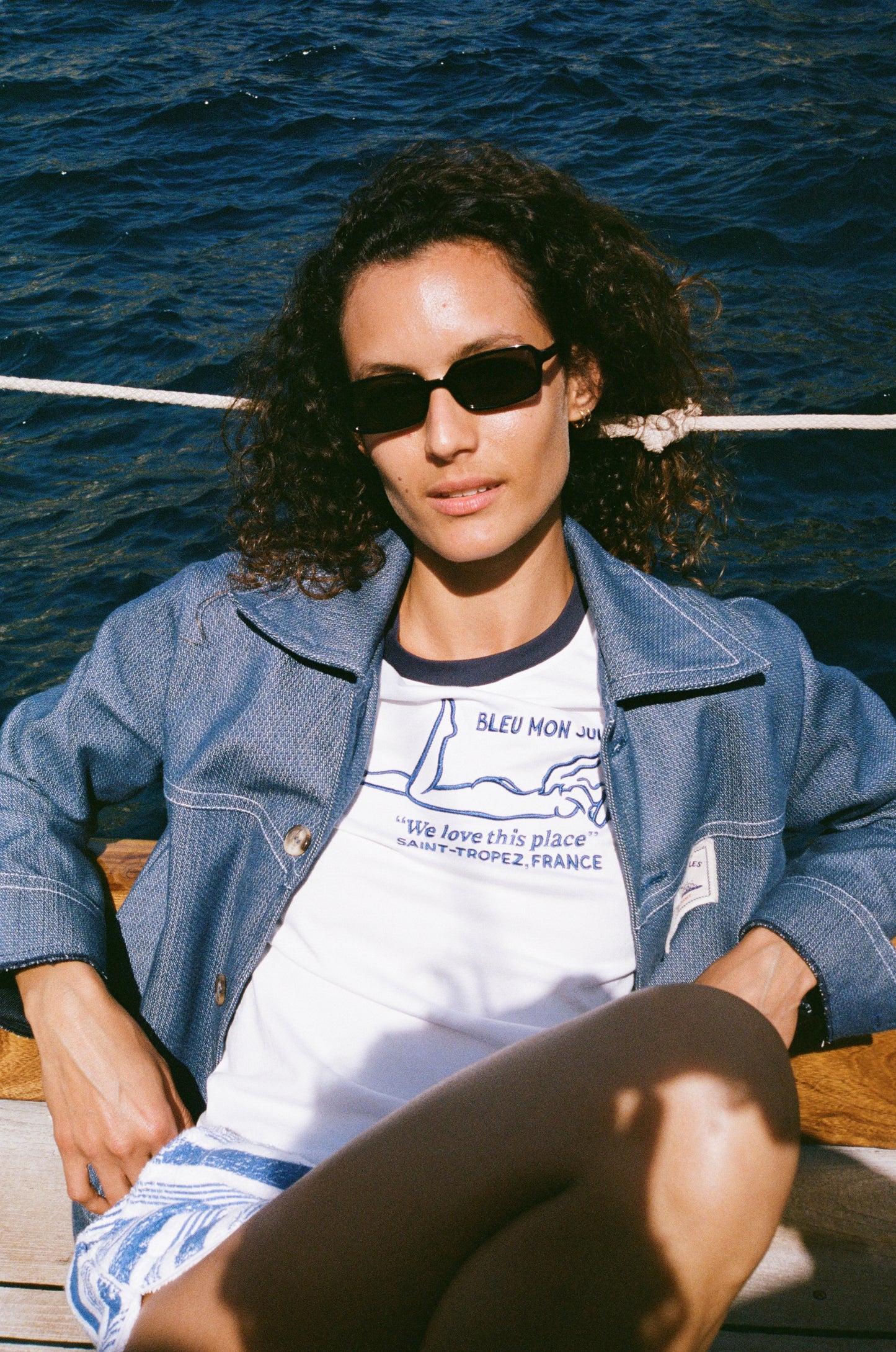 Veste jean Bleu mon Jules portée ouverte sur t-shirt, bord de mer, voilier