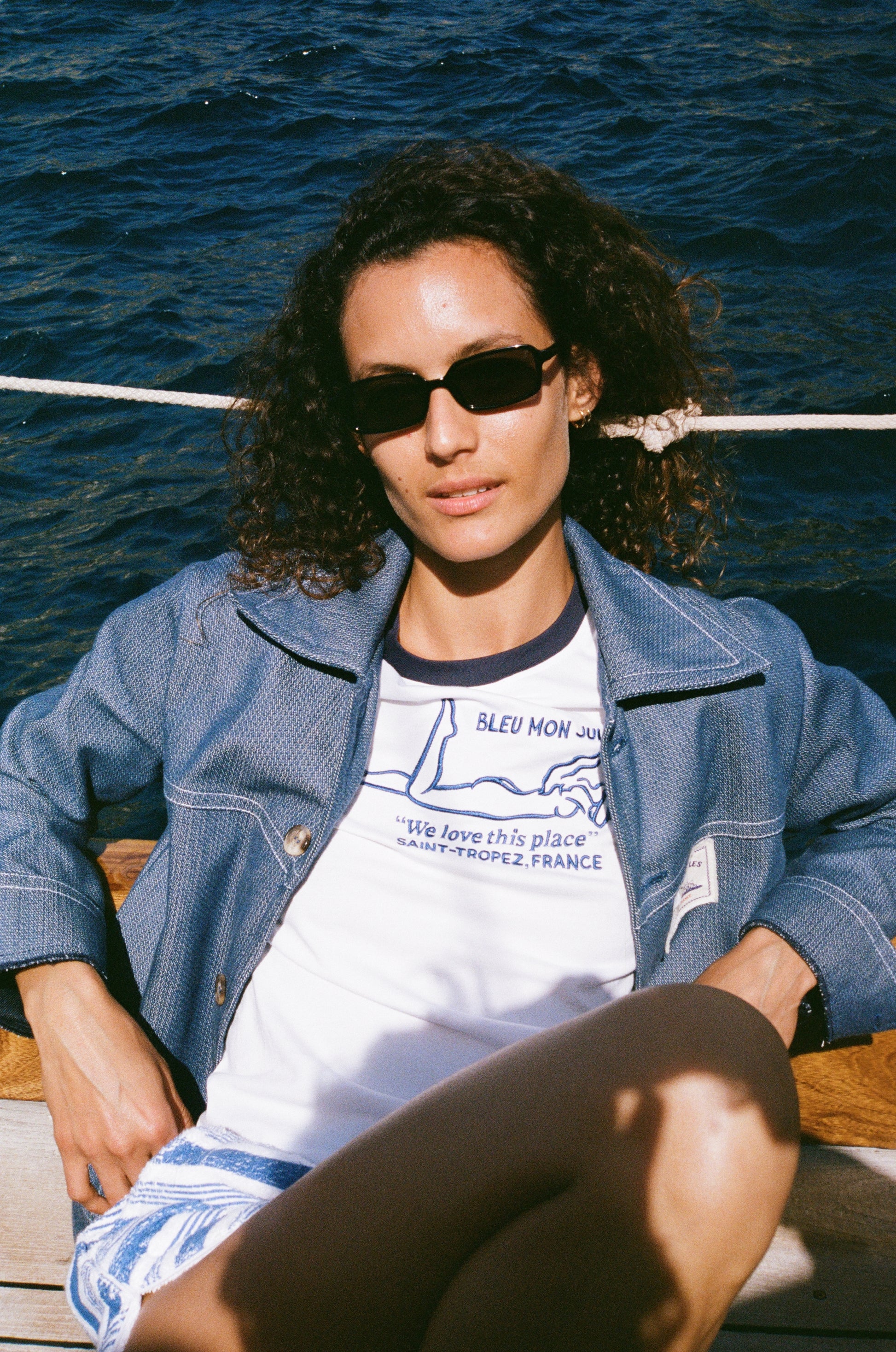 Veste jean Bleu mon Jules portée ouverte sur t-shirt, bord de mer, voilier